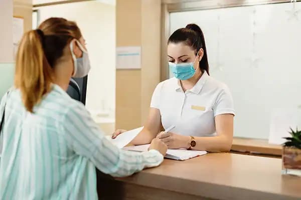 موظفة استقبال تسجّل بيانات مراجعة